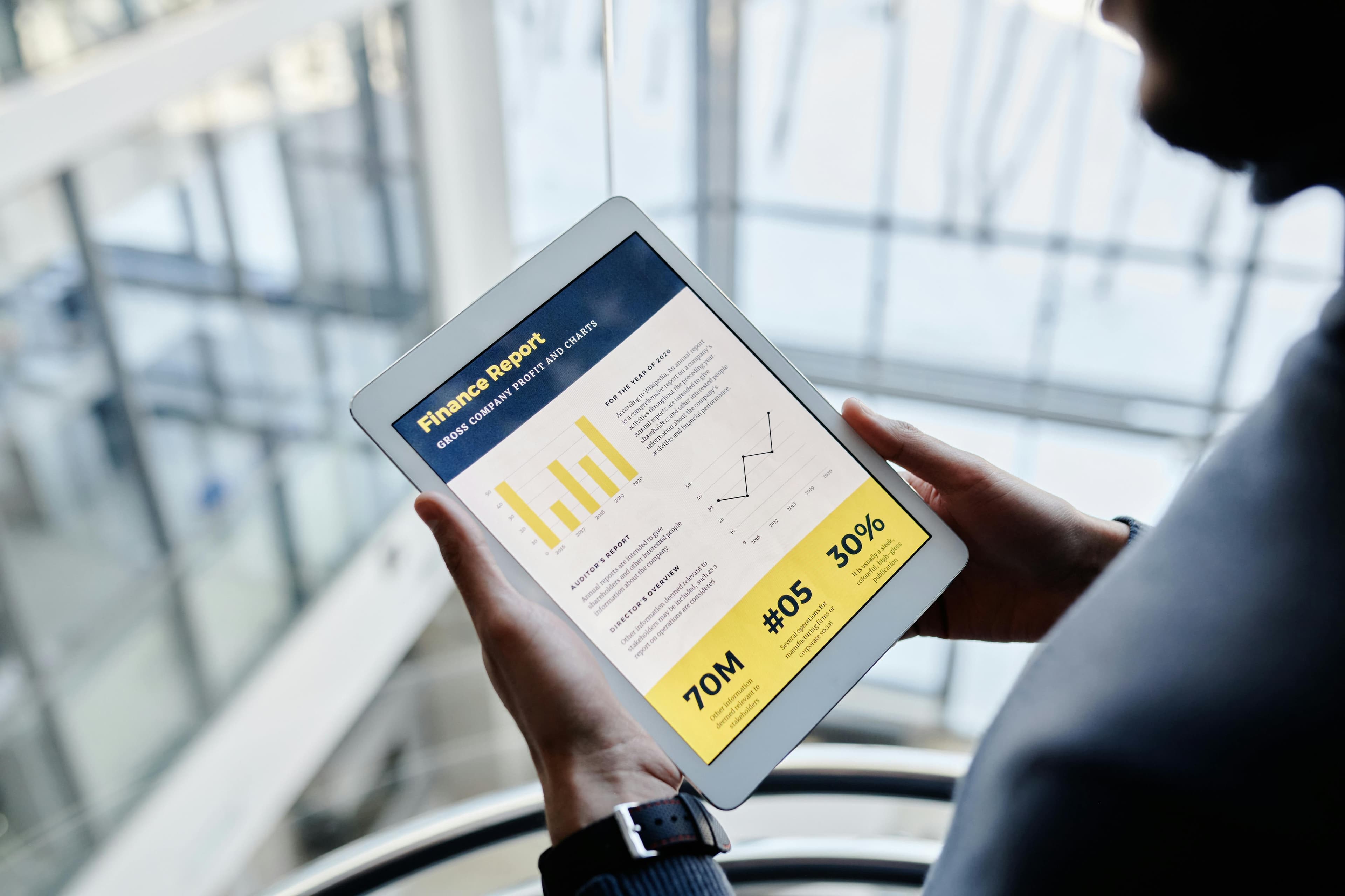 Finance professional reviewing a profit and cost report on a tablet – representing FinOps cloud cost visibility and governance