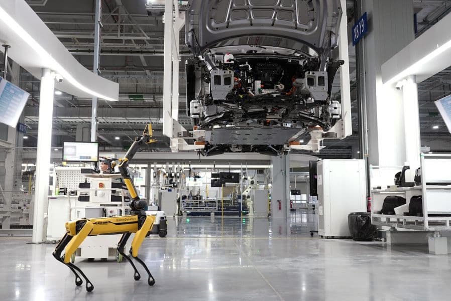 Robotic dog overseeing automated car assembly in a high-tech factory - robotics data collection